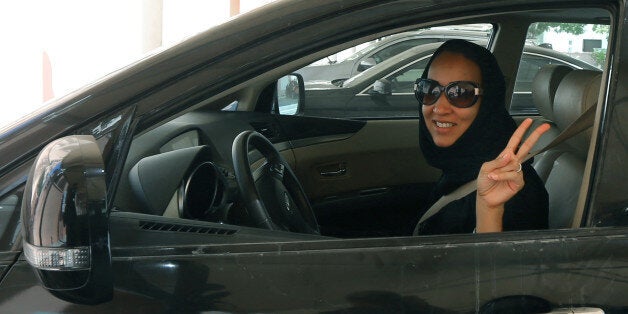 TO GO WITH AFP STORY BY ACIL TABBARA Saudi activist Manal Al Sharif, who now lives in Dubai, flashes the sign for victory as she drives her car in the Gulf Emirate city on October 22, 2013, in solidarity with Saudi women preparing to take to the wheel on October 26, defying the Saudi authorities, to campaign women's right to drive in Saudi Arabia. Under the slogan ' driving is a choice ', activists have called on social networks for women to gather in vehicles on October 26, the culmination of t