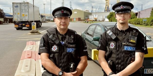 Police officers stand by the main entrance to Tilbury Docks in Essex, where a shipping container was found with illegal immigrants inside with one dead and the rest ill and taken to hospital.