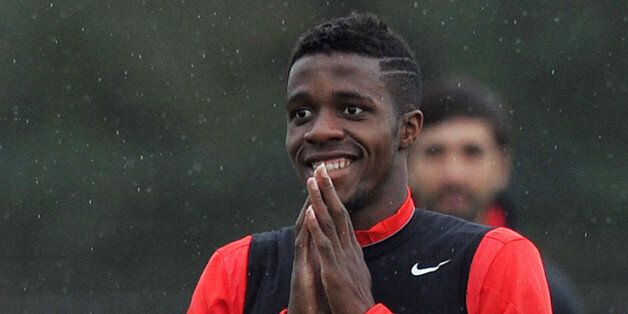 Manchester United's Ivorian-born English striker Wilfried Zaha smiles as he takes part in a training session in Manchester, Northwest England, on October 22, 2014, ahead of the team's Champions League group A football match against Real Sociedad on October 23. AFP PHOTO/PAUL ELLIS (Photo credit should read PAUL ELLIS/AFP/Getty Images)
