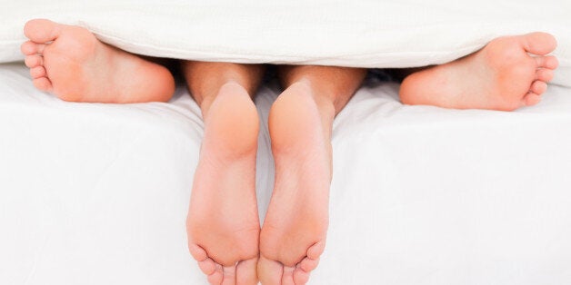 pairs of feet in a bed