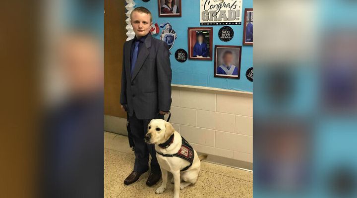 Cameron Cadarette is seen at school with his service dog, Vincent.