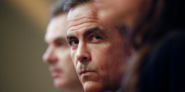 Mark Carney, governor of the Bank of England, center, pauses during the bank's quarterly inflation report news conference in London, U.K., on Wednesday, Aug. 13, 2014. Carney pledged that Bank of England officials won't rush to raise interest rates as he highlighted overseas risks to Britain's recovery and the weakness of wages. Photographer: Simon Dawson/Bloomberg via Getty Images