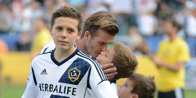 CARSON, CA - DECEMBER 01: David Beckham #23 of Los Angeles Galaxy kisses his sons Brooklyn, Romeo and Cruz before the Galaxy take on the Houston Dynamo in the 2012 MLS Cup at The Home Depot Center on December 1, 2012 in Carson, California. (Photo by Harry How/Getty Images)