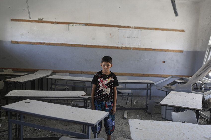 Rayan*, 13, from Shejayia, stands in his destroyed school