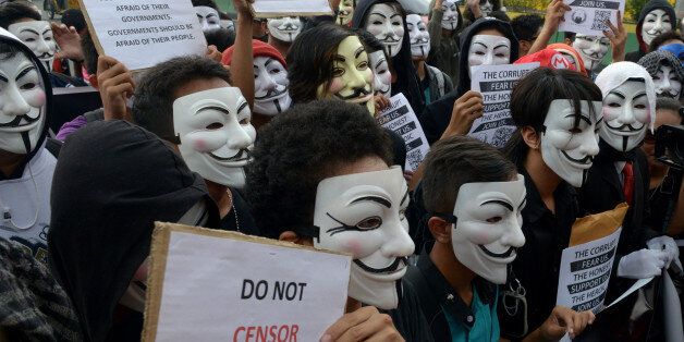 Protesters wearing Guy Fawkes masks display placards during a rally outside the House of Representatives in suburban Quezon city, north of Manila on November 5, 2013. Some 100 masked members of the hacking group Anonymous Philippines marched on parliament on November 5, denouncing corruption and pledging more cyber attacks, a week after 30 government websites were paralysed. AFP PHOTO / Jay DIRECTO (Photo credit should read JAY DIRECTO/AFP/Getty Images)