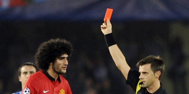 Manchester United's Belgian midfielder Marouane Fellaini (L) receives a red card during the UEFA Champions League Group football match Real Sociedad vs Manchester United at the Anoeta stadium in San Sebastian on November 5, 2013. Match ended 0-0 in a draw. AFP PHOTO / RAFA RIVAS (Photo credit should read RAFA RIVAS/AFP/Getty Images)