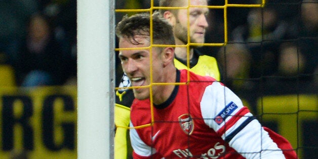 Arsenal's Welsh midfielder Aaron Ramsey (C) celebrates scoring past Dortmund's goalkeeper Roman Weidenfeller (L) during the UEFA Champions League group F football match Borussia Dortmund vs Arsenal London in Dortmund, western Germany on November 6, 2013. AFP PHOTO / ODD ANDERSEN (Photo credit should read ODD ANDERSEN/AFP/Getty Images)