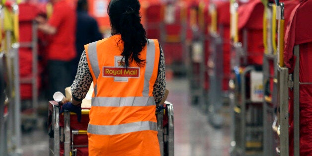 A Royal Mail Plc employee pushes a trolley of un-sorted parcels through the sorting area at the company's Mount Pleasant postal sorting office in London, U.K., on Tuesday, Feb. 11, 2014. Royal Mail, the U.K. postal service that sold shares in an initial public offering last year, said like-for-like sales gained 2 percent in the first nine months of the year boosted by parcel deliveries. Photographer: Chris Ratcliffe/Bloomberg via Getty Images