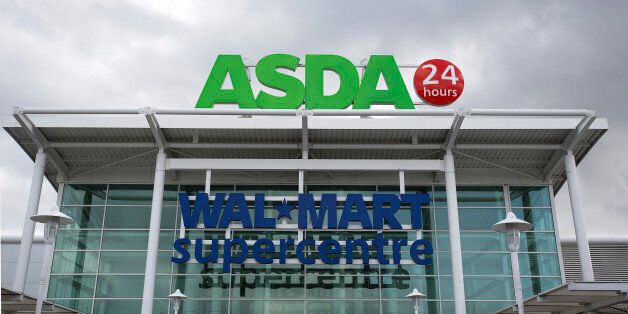 A logo sits above the entrance to an Asda supermarket, the U.K. retail arm of Wal-Mart Stores Inc., in Watford, U.K., on Thursday, Oct. 17, 2013. U.K. retail sales rose more than economists forecast in September as an increase in furniture demand led a rebound from a slump the previous month. Photographer: Simon Dawson/Bloomberg via Getty Images