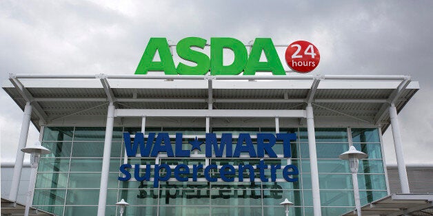 A logo sits above the entrance to an Asda supermarket, the U.K. retail arm of Wal-Mart Stores Inc., in Watford, U.K., on Thursday, Oct. 17, 2013. U.K. retail sales rose more than economists forecast in September as an increase in furniture demand led a rebound from a slump the previous month. Photographer: Simon Dawson/Bloomberg via Getty Images