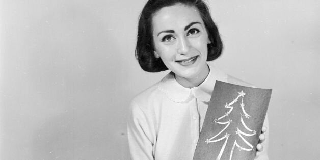 circa 1956: A woman holding a homemade Christmas card. (Photo by Three Lions/Getty Images)