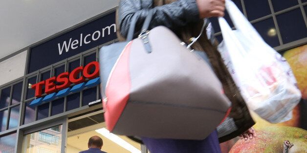 A customer leaves a Tesco Metro supermarket store, operated by Tesco Plc, in London, U.K., on Friday, Aug. 29, 2014. Tesco Plc unexpectedly slashed its dividend and reduced investment as the largest U.K. retailer was squeezed between German discount chains and upscale stores such as Waitrose, driving the stock to the lowest in almost 11 years. Photographer: Chris Ratcliffe/Bloomberg via Getty Images