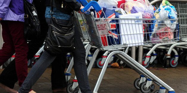 File photo dated 31/12/13 of customers with their shopping leave a Tesco store as Britain's biggest supermarket is expected to post a third successive quarter of worsening sales when latest trading figures are published.