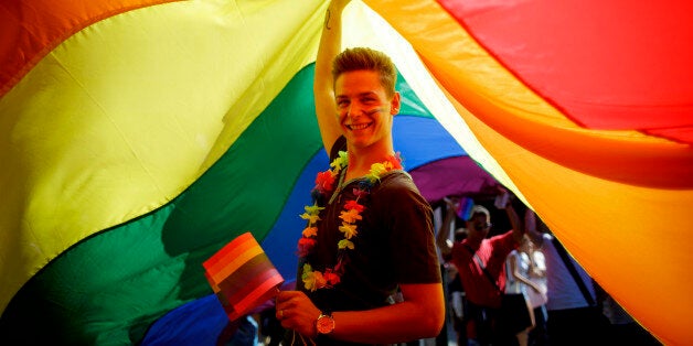 PRAGUE, CZECH REPUBLIC - AUGUST 17: A participant holds up a large rainbow flag during the third Prague Pride March on August 17, 2013 in Prague, Czech Republic. Several thousand people marched through city centre in support of Lesbian, Gay, Bisexual and Transgenders (LGBT) rights. (Photo by Matej Divizna/Getty Images)