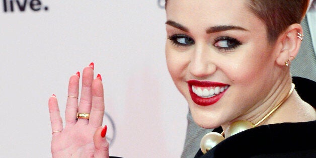 US singer Miley Cyrus poses for photographers on the red carpet as she arrives for the Bambi awards at the Stage theatre at Potsdamer Platz in Berlin on November 14, 2103. The awards ceremony ubder the patronage of German publisher Hubert Burda and awards nominees in the sectors of communication, entertainment and show business as well as economy, politics and sports. AFP PHOTO / JOHN MACDOUGALL ALTERNATIVE CROP (Photo credit should read JOHN MACDOUGALL/AFP/Getty Images)