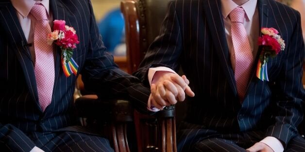 Phil Robathan (L) and James Preston (R) hold hands during their wedding ceremony in Brighton, southern England, on March 29, 2014. Gay couples across England and Wales said 'I do' as a law legalising same-sex marriage came into effect at midnight, the final stage in a long fight for equality. AFP PHOTO / LEON NEAL (Photo credit should read LEON NEAL/AFP/Getty Images)