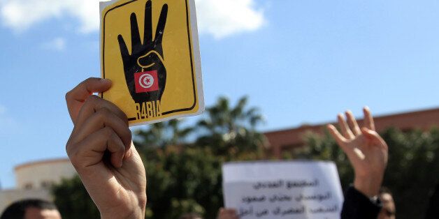 Tunisians flash 'Rabia' sign as they gather outside the Egyptian embassy in Tunis to protest the Egyptian judge's decision on Tuesday to sentence 528 supporters of the Muslim Brotherhood to death on March 28, 2014. (Photo by Yassine Gaidi/Anadolu Agency/Getty Images)