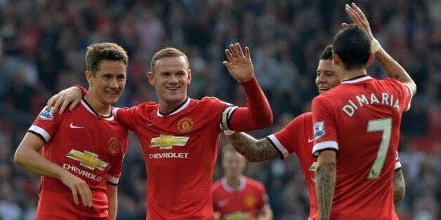 Manchester United's English striker Wayne Rooney (2nd L) celebrates scoring their third goal with teammates during the English Premier League football match between Manchester United and Queens Park Rangers at Old Trafford in Manchester, north west England on September 14, 2014. AFP PHOTO/PAUL ELLISRESTRICTED TO EDITORIAL USE. No use with unauthorized audio, video, data, fixture lists, club/league logos or live services. Online in-match use limited to 45 images, no video emulation. No use in betting, games or single club/league/player publications. (Photo credit should read PAUL ELLIS/AFP/Getty Images)