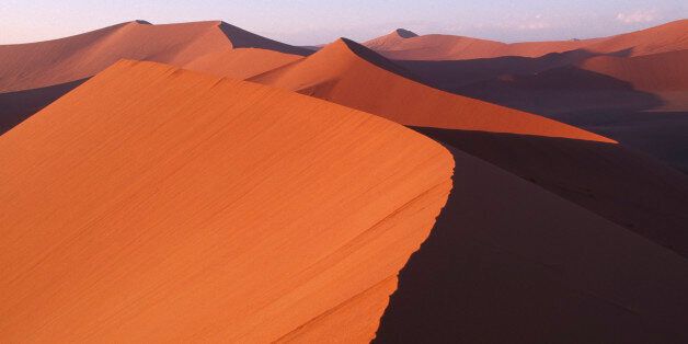 NAMIBIA Namib Desert Red sand dunes partially cast in shadow