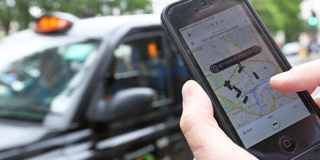 A user scans for an available vehicle using the Uber Technologies Inc.'s app on an Apple Inc. iPhone 5 smartphone in this arranged photograph in London, U.K., on Friday, May 30, 2014. London's taxis are planning a 10,000-cab protest next month, as professional drivers across Europe demonstrate growing opposition to the Uber app. Photographer: Chris Ratcliffe/Bloomberg via Getty Images