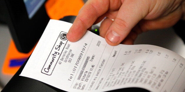 An employee holds a customer's receipt in this arranged photograph inside the Community shop, a supermarket for low-income families, in Goldthorpe, U.K., on Monday, Dec. 23, 2013. Company Shop Ltd. created the Community shop for people in, or bordering on, food poverty, selling surplus goods from major retailers at discounted prices. Photographer: Paul Thomas/Bloomberg via Getty Images