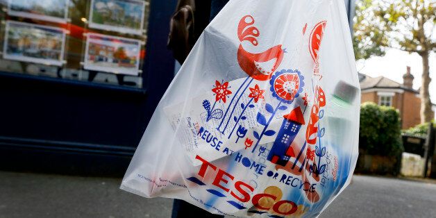 A shopper carries a Tesco supermarket bag in London, Monday, Sept. 22, 2014. Tesco, Britain's largest retailer by revenue, has suspended four executives and launched an accounting investigation after admitting that its half-year profit was overstated by 250 million pounds ($407 million). (AP Photo/Kirsty Wigglesworth)