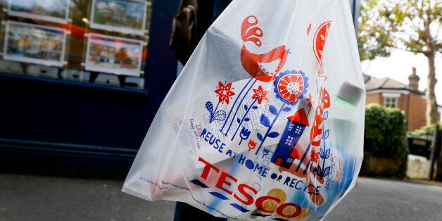 A shopper carries a Tesco supermarket bag in London, Monday, Sept. 22, 2014. Tesco, Britain's largest retailer by revenue, has suspended four executives and launched an accounting investigation after admitting that its half-year profit was overstated by 250 million pounds ($407 million). (AP Photo/Kirsty Wigglesworth)