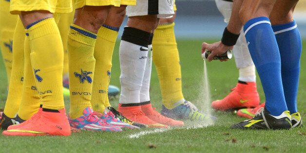VERONA, ITALY - AUGUST 30: Referee Carmine Russo uses vanishing spray to mark the Chievo Verona wall during the Serie A match between AC Chievo Verona and Juventus FC at Stadio Marc'Antonio Bentegodi on August 30, 2014 in Verona, Italy. (Photo by Dino Panato/Getty Images)