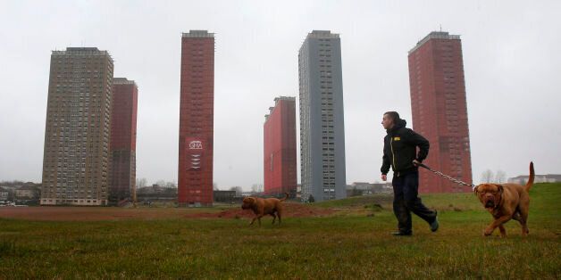 A man walks his dog by the Red Road flats in Glasgow that will be demolished live during the opening ceremony of the Commonwealth Games.