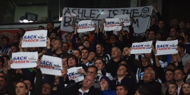 STOKE ON TRENT, ENGLAND - SEPTEMBER 29: Newcastle fans hold up signs calling for Alan Pardew, manager of Newcastle United, to be sacked as they watch the Barclays Premier League match between Stoke City and Newcastle United at Britannia Stadium on September 29, 2014 in Stoke on Trent, England. (Photo by Laurence Griffiths/Getty Images)