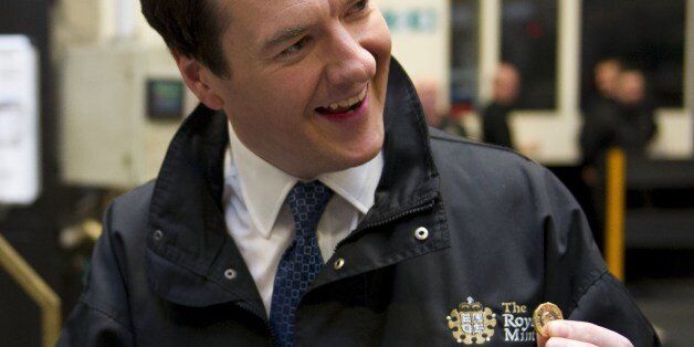 Britain's Chancellor of the Exchequer George Osborne holds freshly minted coins during a visit to the Royal Mint in Llantrisant, Wales on March 25, 2014. In events surrounding the Chancellor's recent budget, a new design was revealed for a 12-sided one pound coin, designed to be much harder to fake and based on the pre-decimal 'threepenny bit' three pence piece. AFP PHOTO/POOL/Matthew Horwood (Photo credit should read MATTHEW HORWOOD/AFP/Getty Images)