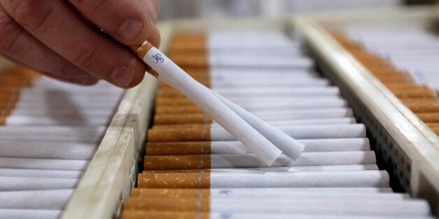 An employee checks finished John Player Special (JPS) cigarettes, manufactured by Imperial Tobacco Group Plc, at the company's factory in Nottingham, U.K., on Friday, Feb. 1, 2013. Imperial Tobacco Group Plc is Europe's second-biggest tobacco company and generates about 40 percent of its profit from the region. Photographer: Chris Ratcliffe/Bloomberg via Getty Images