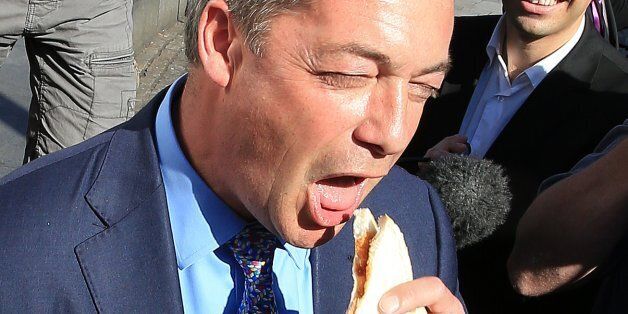 Leader of the Ukip party Nigel Farage eating a bacon sandwich during a visit to the Heywood and Middleton constituency ahead of the by-election next week.