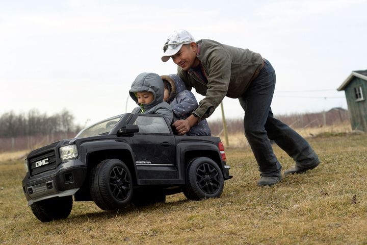 Eladio Beltran, right, pushes his children in a car at their home in Albion, New York. Beltran faces deportation because he was arrested for driving without a license. He is one of the many undocumented workers hoping to benefit from the "Green Light" bill.