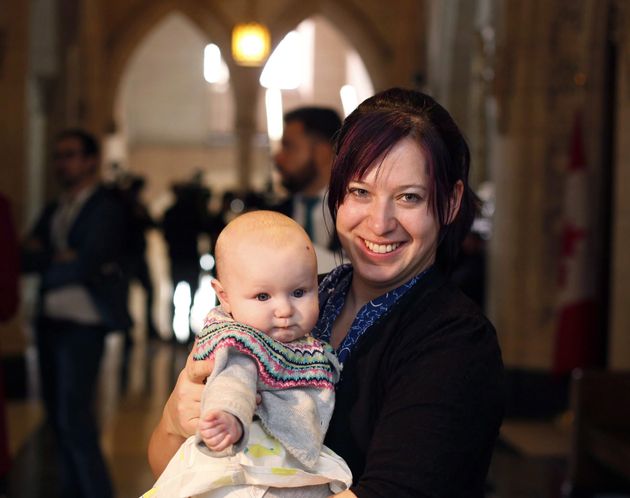 NDP MP Christine Moore holds her daughter Daohnee just outside the House of Commons,on Parliament Hill on March 8, 2016.