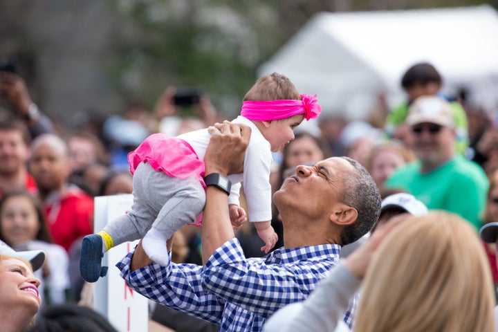 Obama plays with a baby at the 138th Annual Easter Egg Roll at the White House in March 2016.