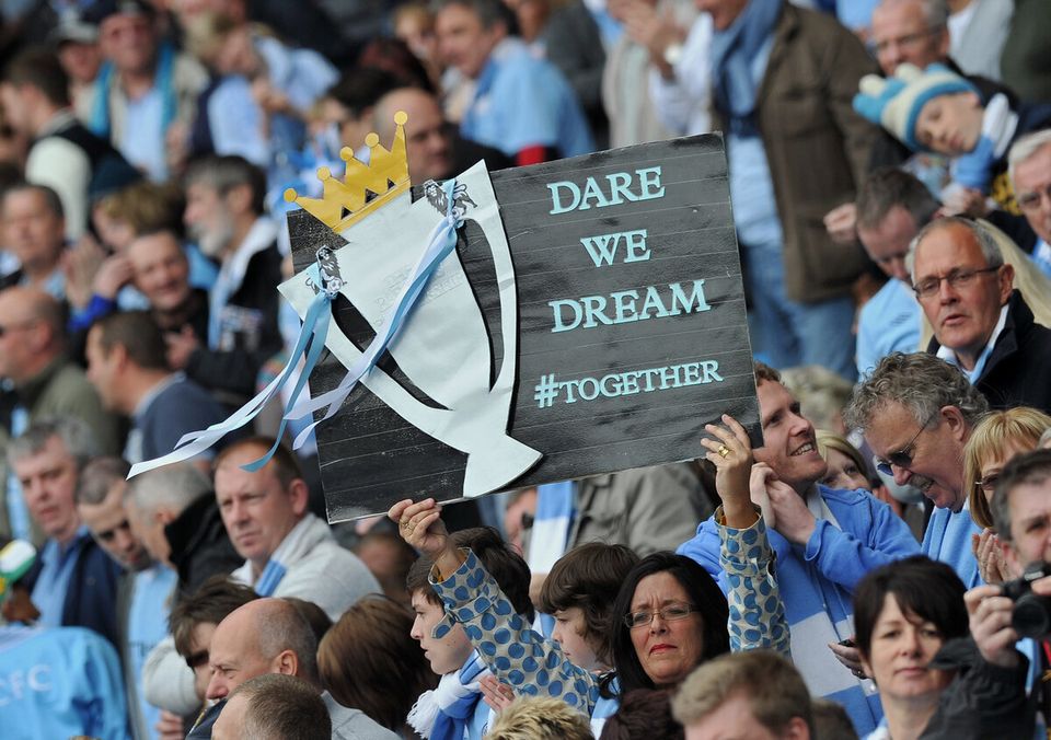 Manchester City supporters hold a home-m