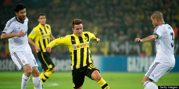 Dortmund's midfielder Mario Goetze (C) vies for the ball with Real Madrid's Portuguese defender Pepe (R) and Real Madrid's defender Sergio Ramos during the UEFA Champions League Group D football match BVB Borussia Dortmund vs Real Madrid in Dortmund, western Germany on October 24, 2012. AFP PHOTO / ODD ANDERSEN (Photo credit should read ODD ANDERSEN/AFP/Getty Images)