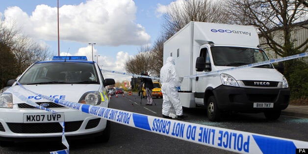 Forensic police officers examine evidence at the crime scene where two men escaped from a prison van that came under attack on Regent Road in Salford.