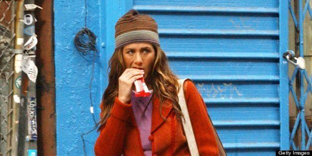 Photo by Arnaldo Magnani/Getty Image: Actress Jennifer Aniston eating candy bar while filming Along Came Polly