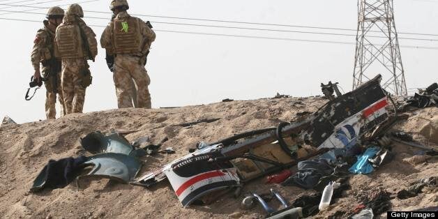 British soldiers stand by debris strewn on the side of the road after a bus carrying Iraqi pilgrims crashed into back of a British Army armoured vehicle late last night west of the city of Basra, some 550kms from Baghdad on February 18, 2009. Four Iraqi pilgrims were killed when the bus ran into the back of the British armoured vehicle during a sandstorm officials said. The bus was carrying pilgrims returning from the holy city of Karbala where several million pilgrims had made the trek for the Arbaeen ceremony earlier this week which marks 40 days after the Ashura anniversary of the killing of Imam Hussein in AD 680.AFP PHOTO / ESSAM AL-SUDANI (Photo credit should read ESSAM -AL-SUDANI/AFP/Getty Images)