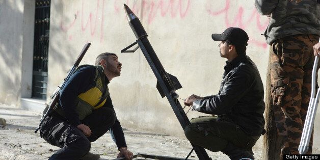 Rebel fighters prepare to launch of a rocket in the Saif al-Dawla district of the northern Syrian city of Aleppo