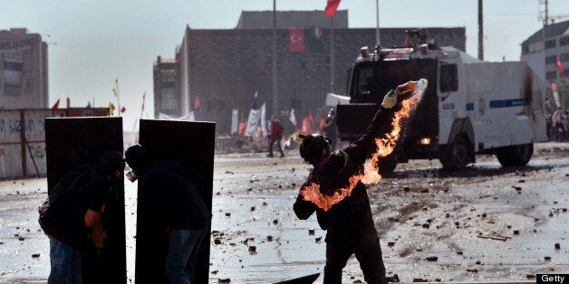 A protester throws a Molotov cocktail durign clashes with riot police in istanbul's Taksim square on June 11, 2013. Turkish Prime Minister Recep Tayyip Erdogan on June 11 said three protesters and one police officer have been killed in nearly two weeks of nationwide unrest against his Islamic-rooted government. AFP PHOTO / ARIS MESSINIS (Photo credit should read ARIS MESSINIS/AFP/Getty Images)