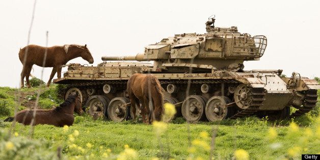 A picture taken on March 8, 2013 shows horses near a former Israeli tank in a field along the border between Syria and Israel, in the Golan Heights. AFP PHOTO / JACK GUEZ (Photo credit should read JACK GUEZ/AFP/Getty Images)
