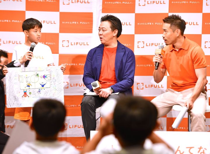 宇宙空間でのサッカーを提案する小学生（左）と話す井上社長（中央）と長友選手