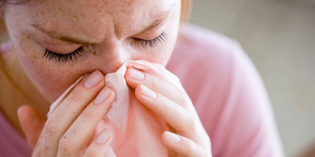 Woman blowing nose