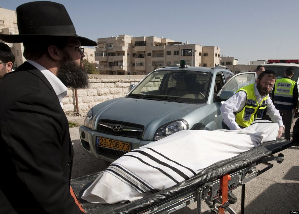 Israeli Zaka Volunteers wheel the body o