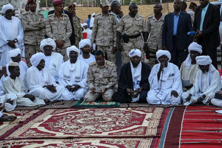 In this file photo from May 18, 2019, Gen. Mohammed Hamdan Dagalo, better known as Hemedti, kneeling center, is the deputy head of the military council that assumed power in Sudan after the overthrow of President Omar al-Bashir.
