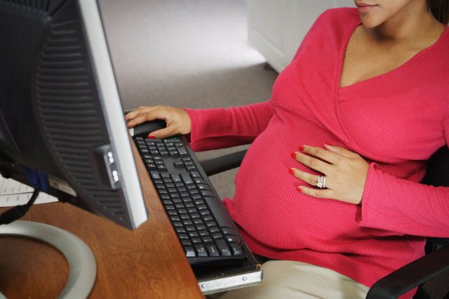 Pregnant woman working on computer