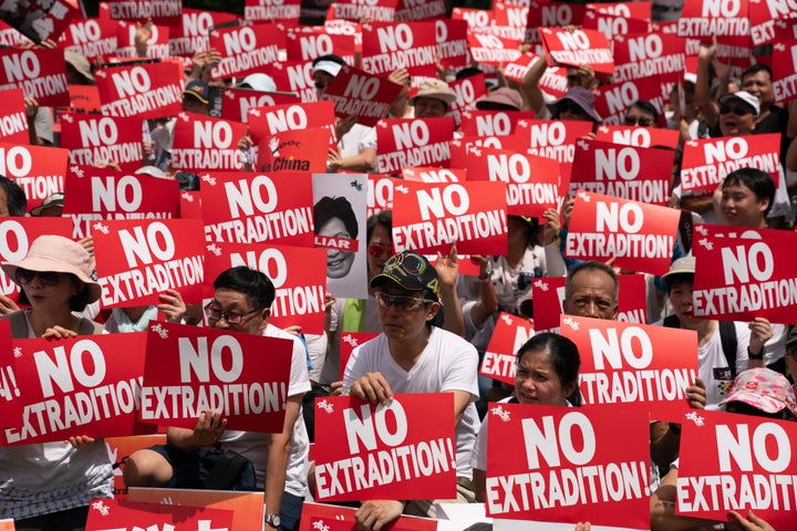 Protesters hold placards and shout slogans during a rally against the extradition law proposal on June 9, 2019. Hong Kong witnessed its largest street protest in at least 15 years on June 9 as crowds massed against plans to allow extraditions to China, a proposal that has sparked a major backlash against the city's pro-Beijing leadership.